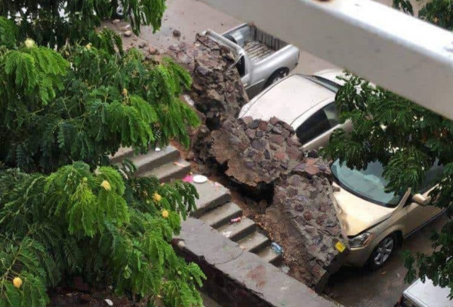 Pared caída sobre cofres de autos