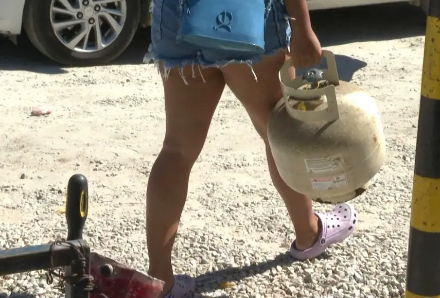 Mujer cargando un cilindro de gas doméstico