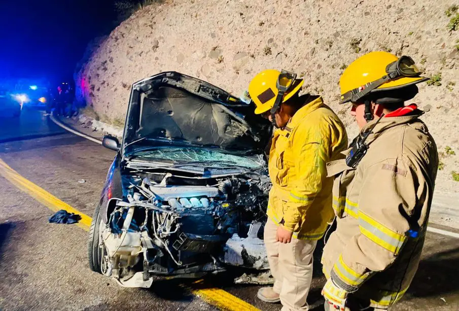 Bomberos supervisando carro destrosado por choque