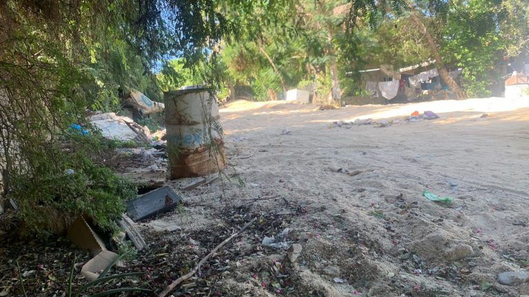 Calle de terracería con botes de basura