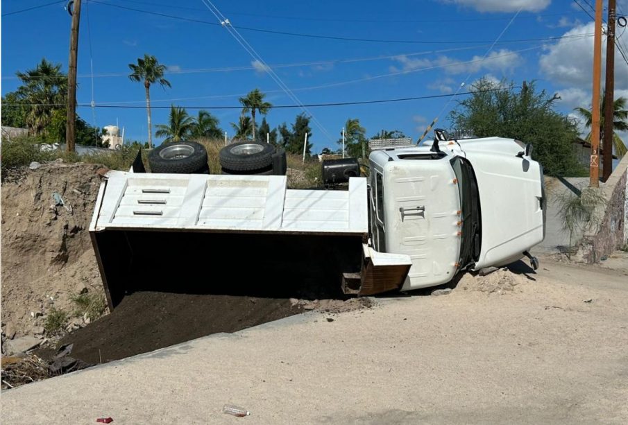 Camión volcado en arroyo