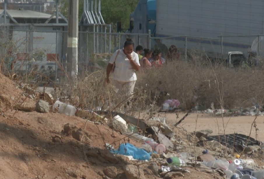 Mujer caminando en calle con basura