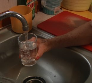 Persona llenando vaso con agua de la llave