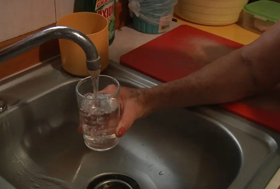 Persona llenando vaso con agua de la llave