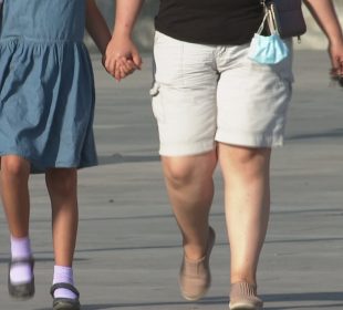 Señora caminando con menor de la mano