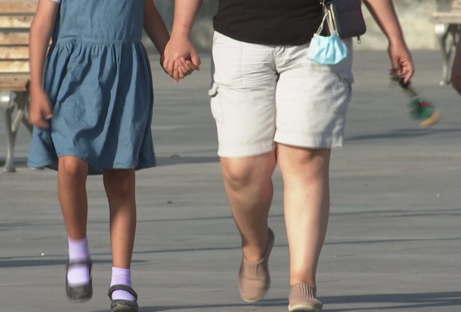 Señora caminando con menor de la mano