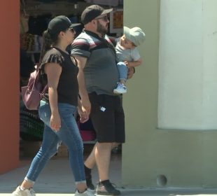 Pareja cargando a menor de edad en brazos