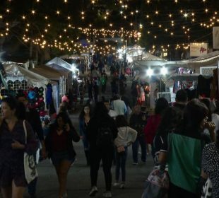 Personas caminando en tianguis navideño