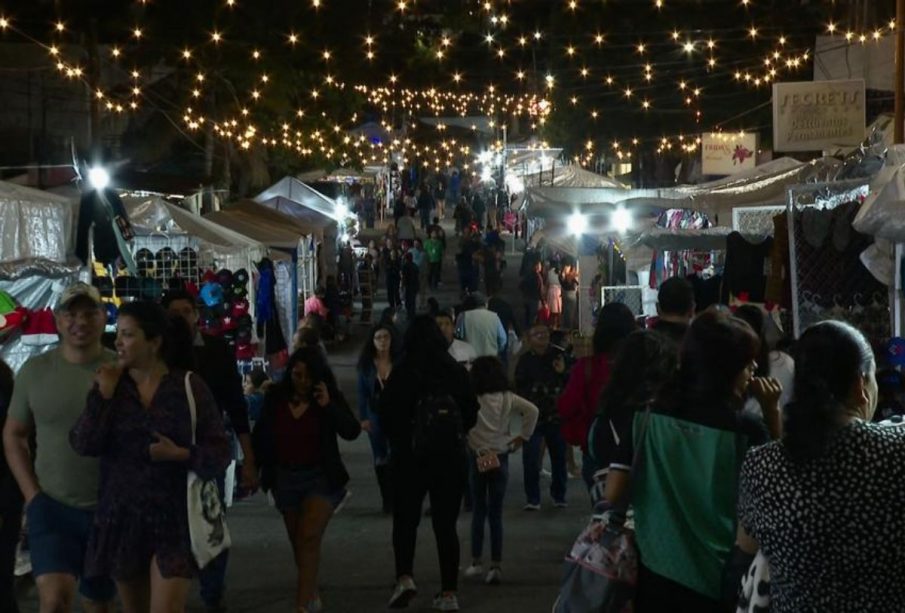 Personas caminando en tianguis navideño