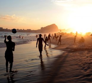 Personas disfrutando atardecer en playa de Los Cabos