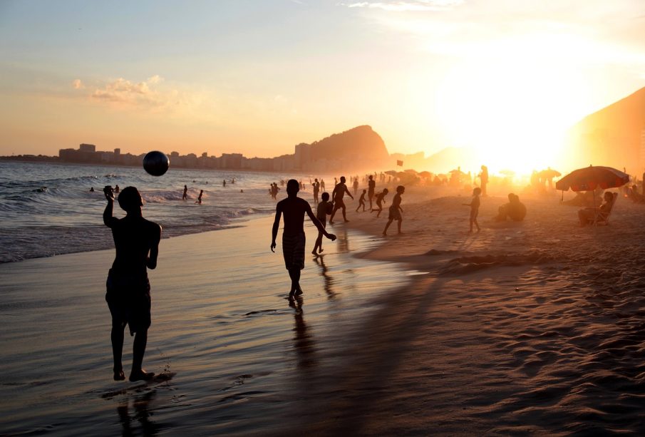 Personas disfrutando atardecer en playa de Los Cabos