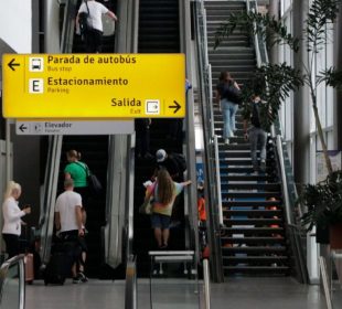 Turistas subiendo escalera de aeropuerto