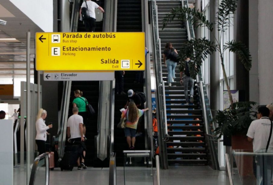 Turistas subiendo escalera de aeropuerto
