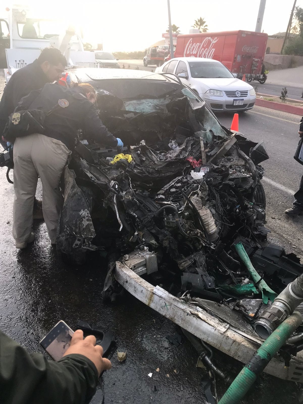 Agentes revisando carro desecho por impactarse en pipa