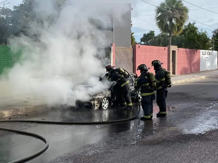 Bomberos sofocando auto incendiado