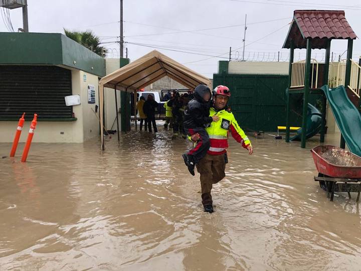 Elemento de PC rescatando a menor de escuela inundada