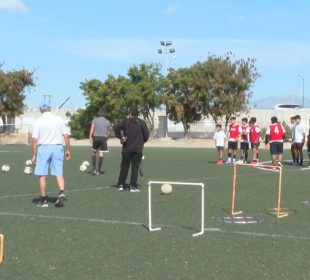 Niños entrenando en cancha de fútbol