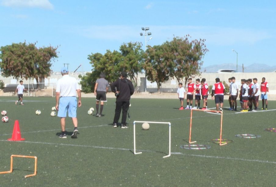 Niños entrenando en cancha de fútbol