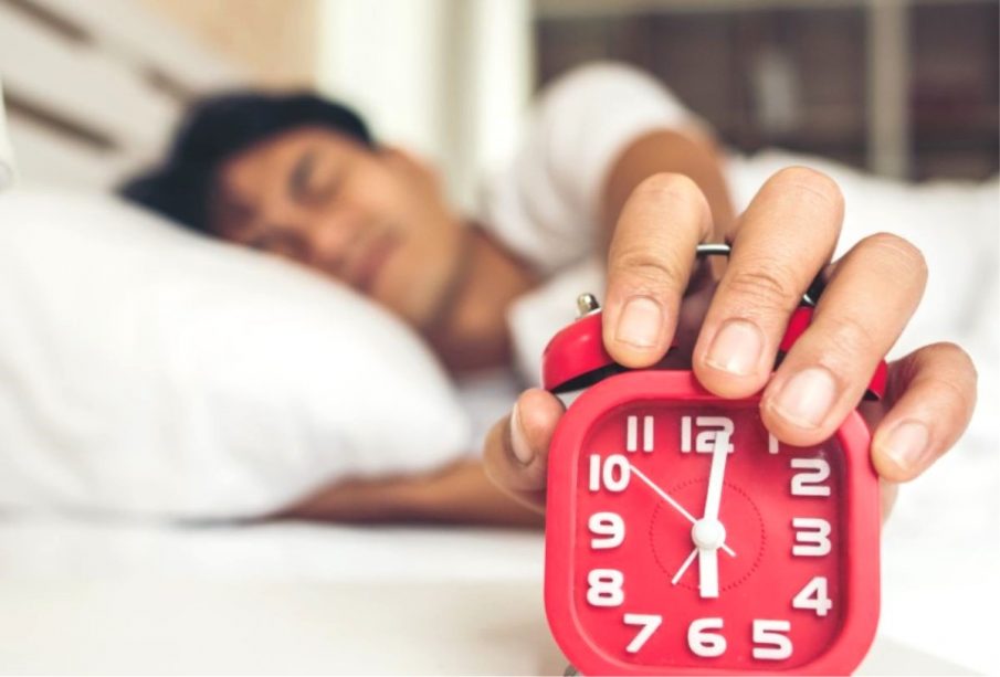 Hombre despertando y apagando el reloj