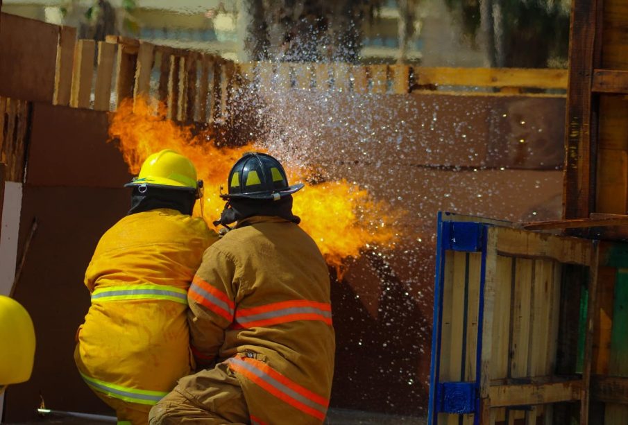 Bomberos apagando fuego en entrenamiento