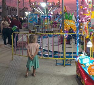 Niña viendo juegos mecánicos