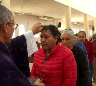 Sacerdote poniendo ceniza en la frente de feligreses