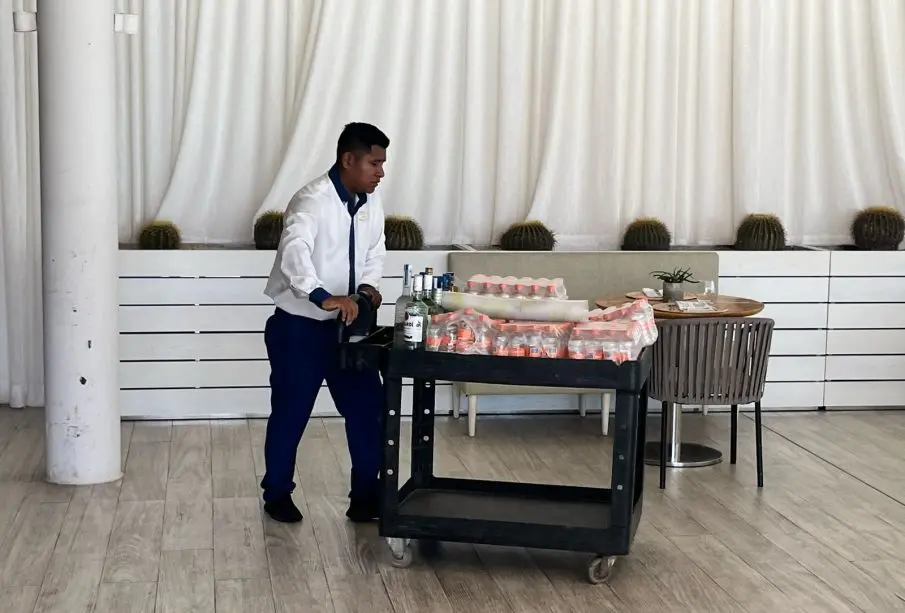 Trabajador llevando carrito de bebidas