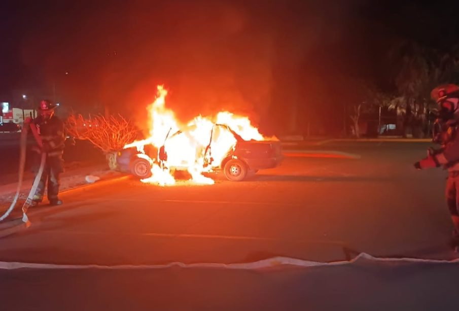 Bomberos extinguiendo incendio en auto