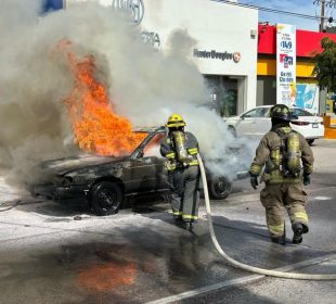 Bomberos sofocando incendio en auto