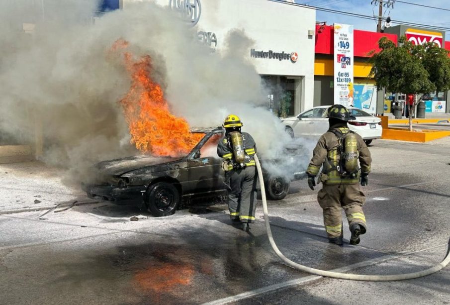 Bomberos sofocando incendio en auto