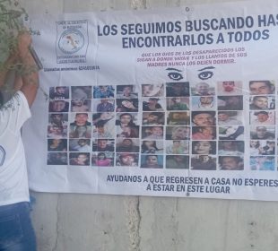 Madre buscadora colocando manta de desaparecidos