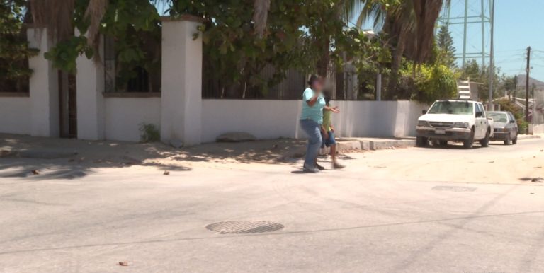 Mujer caminando con niño por la calle