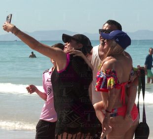 Turistas tomándose fotos en la playa