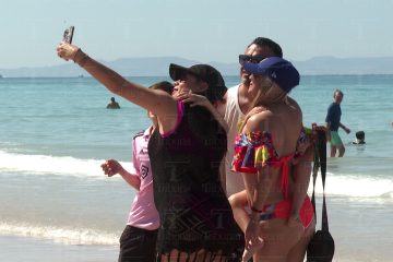 Turistas tomándose fotos en la playa