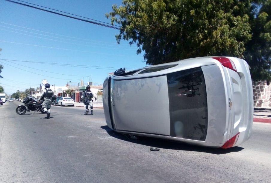 Vehículo plateado volcado en la carretera