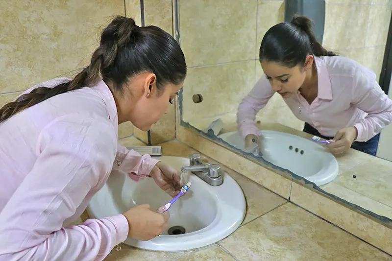 Mujer se lava los dientes en el lavabo con agua potable de La Paz