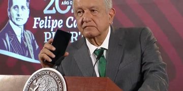 AMLO sosteniendo telefono por informe de obras en BC