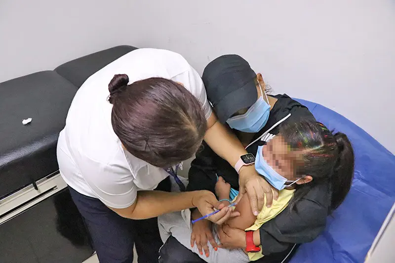 Enfermera vacunando a niña
