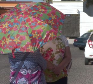 Mujeres con sombrilla bajo el sol