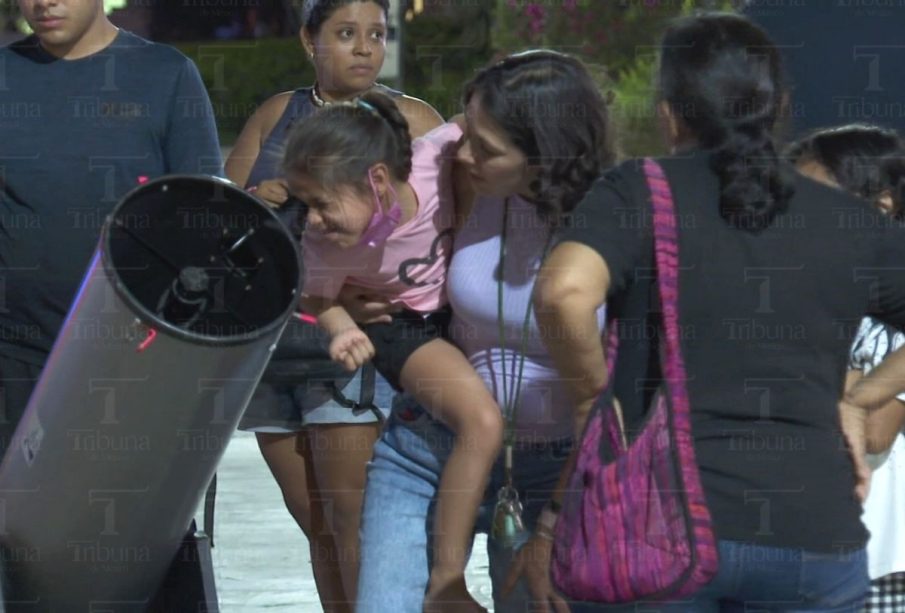 Niña y su mamá viendo el cielo en un telescopio