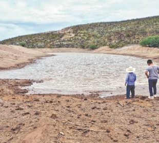 Río con agua corriendo y dos granjeros observan correr el agua