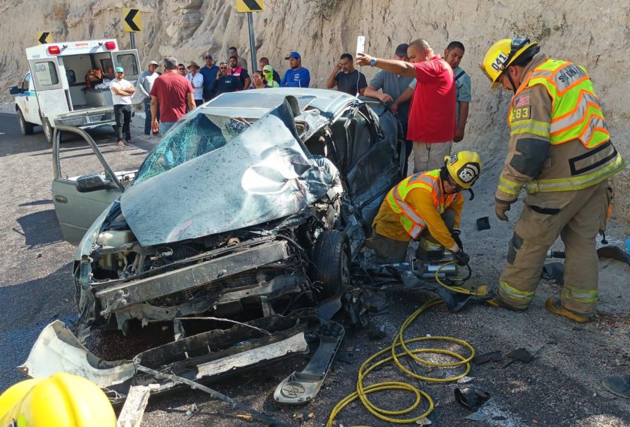 Bomberos rescatando a persona en auto