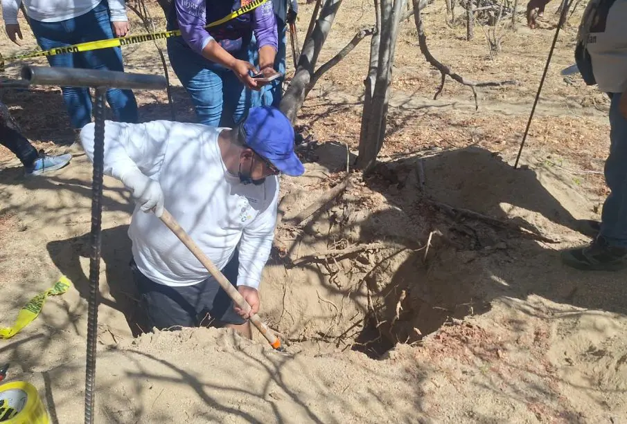 Hombre cavando en fosa clandestina