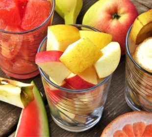 Diversidad de fruta picada en un vaso de vidrio