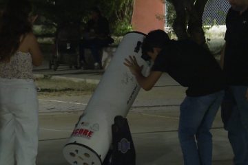 personas viendo en telescopio