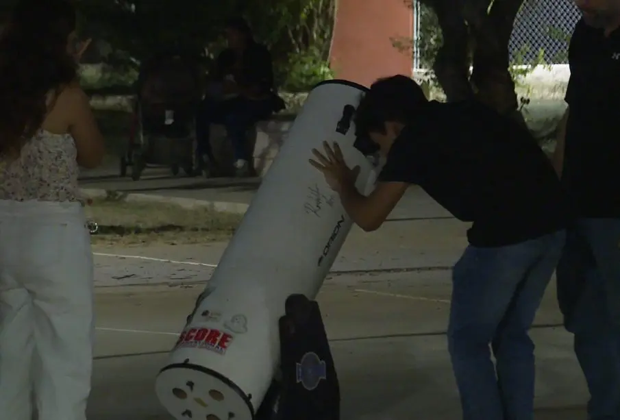 personas viendo en telescopio