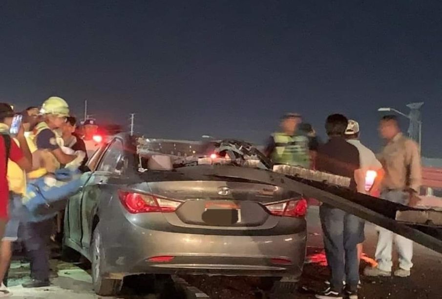 Autoridades y personas rescandando a persona atrapasa en coche tras accidente