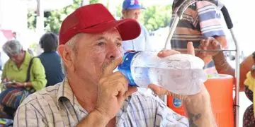 Señor tomando agua por calor extremo