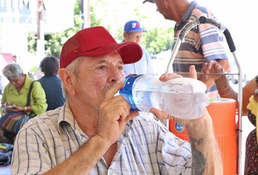 Señor tomando agua por calor extremo