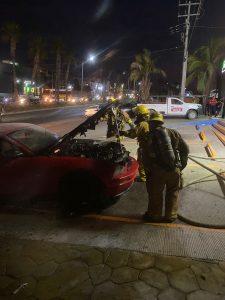 Bomberos apagando incendio vehicular